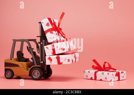 Gabelstapler und Geschenkboxen auf rosa Hintergrund mit Kopierraum. Valentinstag. Hochzeitstag Stockfoto