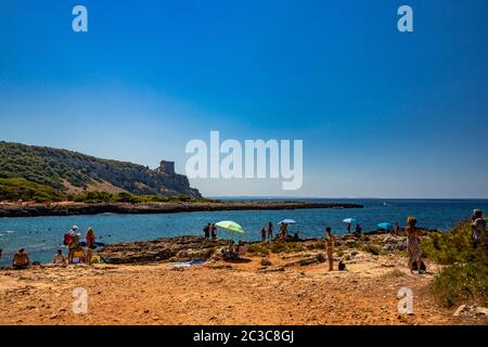 20. August 2019 - Nardò, Italien, Apulien, Salento - Bucht von Porto Selvaggio. Kiesstrand und felsiger Strand. Die Menschen sonnen sich und schwimmen im türkisfarbenen Meer. Das T Stockfoto