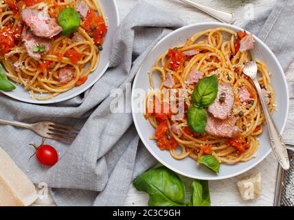 Spaghetti mit Stücken von frischem Thunfisch, Tomaten und Kapern Nahaufnahme Stockfoto