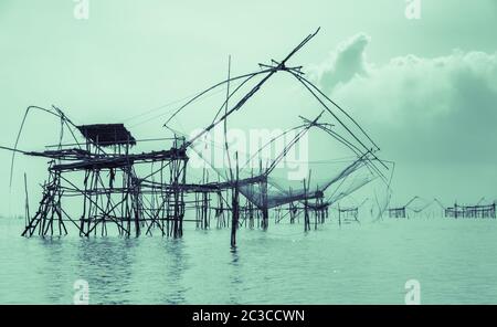 Silhouette Chinesische Fischernetze oder Landaufzugsnetze in Phatthalung, Thailand. Vintage Farbeffekt Bild Stockfoto