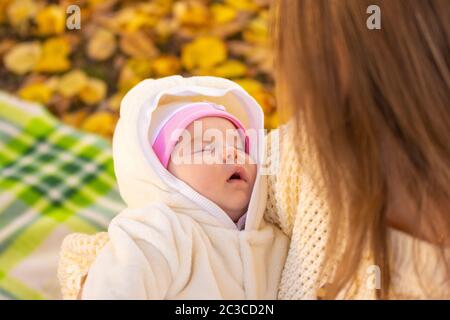 Das zwei Monate alte Baby schläft in den Armen der Mutter Stockfoto