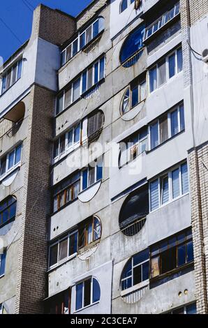 Fassade von Wohngebäuden mit lockigen Balkonen. Mehrstöckiges Ziegelgebäude auf blauem Himmel. Sammlung Stadtlandschaften. Selektive FOC Stockfoto