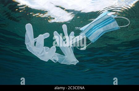 Gesichtsmaske und Handschuhe unter der Wasseroberfläche im Ozean, Plastikmüll Verschmutzung seit Coronavirus COVID-19 Pandemie Stockfoto