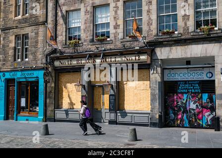 Edinburgh, Schottland, Großbritannien, 19. Juni 2020. Black Lives Matter Mural Trail: An Kunstorten entwickelt sich eine neue Spur von Kunstwerken, um die BLM-Kampagne zu unterstützen, die vom Kunstproduzent wezi Mhura initiiert wurde. Im Bild: Kunstwerke des Graffiti-Kollektivs in Dancebase und der Black Bull-Kneipe im Grassmarket, während eine Frau vorbeigeht Stockfoto