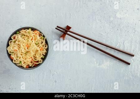 Soba-Schüssel mit Karotten und Hengsten, Gemüsesoba-Schüssel, Kopfschuss mit Essstäbchen und Kopierraum Stockfoto