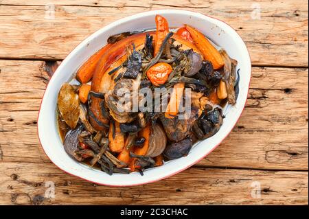 Gebratenes Schweinefleisch knuckelt eisbein mit Gemüse auf Holzhintergrund.Appetitliche bayrisch gegrillte Schweineknäuel Stockfoto