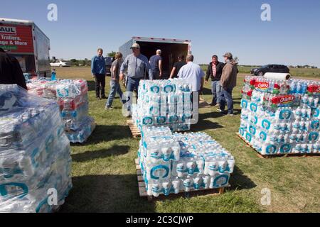 West, Texas, USA, April 19 2013: Freiwillige entladen Paletten mit abgefülltem Wasser, um sie zwei Tage zuvor an die Opfer der Explosion einer Düngemittelanlage zu verteilen. Die Explosion und der daraus resultierende Brand töteten 14 Menschen, verletzten Dutzende und zerstörten oder beschädigten Hunderte von Häusern und Betrieben in der Kleinstadt. ©Marjorie Kamys Cotera/Daemmrich Photography Stockfoto