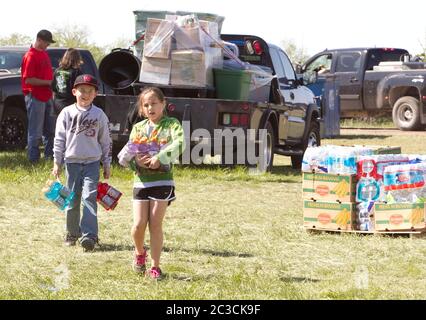 West, Texas, USA, April 19 2013: Kinder tragen gespendete Getränke in Flaschen, um sie an die Opfer einer Explosion einer Düngemittelfabrik zwei Tage zuvor zu verteilen. Die Explosion und der daraus resultierende Brand töteten 14 Menschen, verletzten Dutzende und zerstörten oder beschädigten Hunderte von Häusern und Betrieben in der Kleinstadt. ©Marjorie Kamys Cotera/Daemmrich Photography Stockfoto