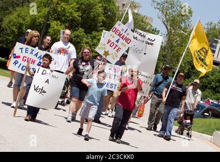 Austin, Texas, USA, Mai 13 2013: Mitglieder einer Gruppe für Waffenrechte tragen bei einer Kundgebung um das Texas Capitol Schilder. Die Marcher zeigten ihre Unterstützung für ein Gesetz, das vom texanischen Gesetzgeber in Erwägung gezogen wurde, das es Studenten mit versteckten Waffenlizenzen erlauben würde, Pistolen in ihre Klassenzimmer zu bringen. ©Marjorie Kamys Cotera/Daemmrich Photography Stockfoto