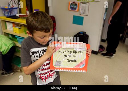 Austin Texas USA, 2013: Der achtjährige mexikanisch-amerikanische Junge zeigt sein Erinnerungsbuch am letzten Tag der ersten Klasse an seiner Grundschule ©Marjorie Kamys Cotera/Daemmrich Photography Stockfoto