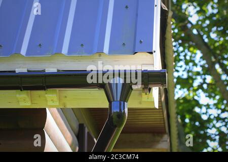 Installation Des Regenrinne-Rohrleitungssystems. Dachkonstruktion. Regenrinne System und Dachschutz vor Schnee. Hausrinnen, Dachrinnen, Dachrinnen Stockfoto