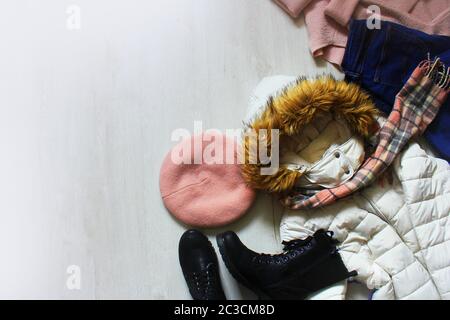 Eine Reihe von angesagten winter Frauen Kleidung. Wolle Pullover, Schuhe, Handtasche, Fell Mütze und Handschuhe auf weißem Holz- Hintergrund. Stockfoto