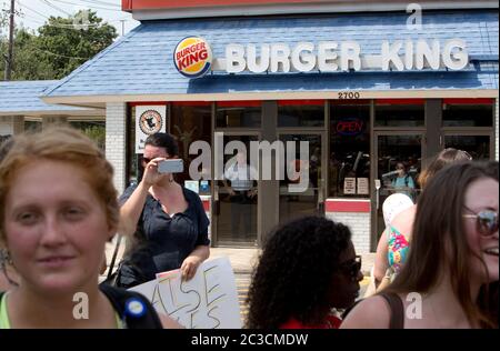 29. August 2013 Austin, Texas, USA: Kunden beobachten von hinter der Restauranttür, wie Fast-Food-Mitarbeiter und Sympathisanten an einem Burger King vorbeiziehen, um gegen niedrige Löhne zu protestieren. ©Marjorie Kamys Cotera/Daemmrich Photography Stockfoto