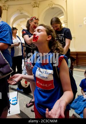 11. Juli 2013 Austin, Texas USA: Junge weibliche Abtreibungsgegnerin betet während einer Pro-Life-Kundgebung im Texas Capitol. Hunderte von Befürwortern des Lebens und Befürwortern der Wahl drängten sich in das Gebäude, als staatliche Senatoren HB2 diskutierten, ein umstrittenes Gesetz, das den Zugang von Frauen zu Abtreibungen strenger einschränke. Der Gesetzentwurf wurde mit 19-11 Stimmen verabschiedet, wobei alle 18 Republikaner und 1 Demokrat Ja stimmten. ©MCK/Bob Daemmrich Photography, Inc Stockfoto