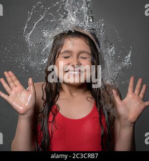 Junges Mädchen fangen Wasser von oben Stockfoto