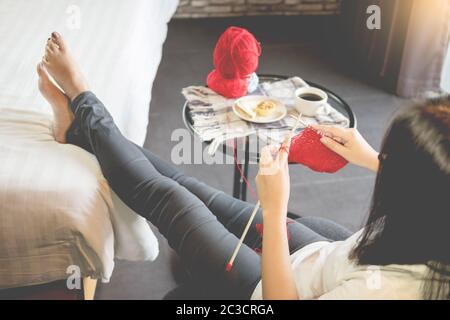 Die junge Frau Hände stricken warme Pullover. Sitzen, die auf einem Sessel in der Nähe der Fenster, entspannende Konzept in Ihrem Schlafzimmer Stockfoto