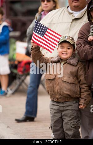 11. November 2014 Austin, Texas, USA: Der kleine Junge winkt mit einer kleinen amerikanischen Flagge, während er die jährliche Parade des Veterans Day entlang der Congress Avenue beobachtet. ©Marjorie Kamys Cotera/Daemmrich Photography Stockfoto