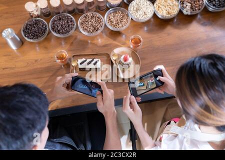 Blick von oben auf die beiden Blogger von jungen erwachsenen Asiatischen Eigentümer Unternehmer bewerten cafe Coffee Shop für Social Media und Online Marketing im Cafe. Verwendung für Star Stockfoto