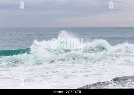 Meeresküste, Bewegungswellen mit Schaum. Windkraft. Türkisfarbenes Wasser. Stockfoto