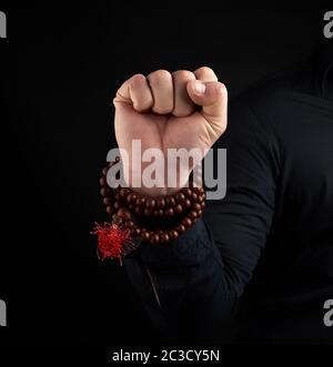 Hand eines erwachsenen Männchens zeigt Mushti Mudra auf einem dunklen Hintergrund, geklaute Faust Stockfoto