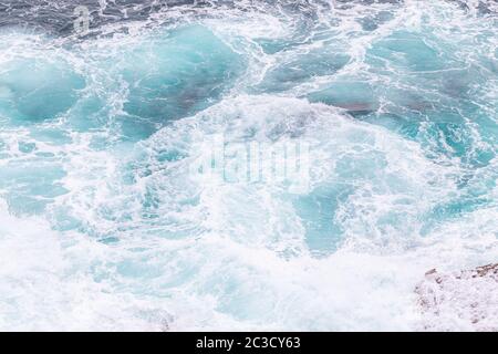 Meeresküste, Bewegungswellen mit Schaum. Windkraft. Türkisfarbenes Wasser. Stockfoto