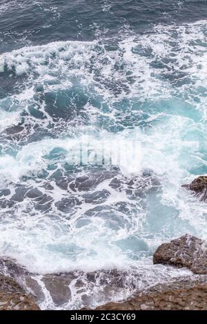 Meeresküste, Bewegungswellen mit Schaum. Windkraft. Türkisfarbenes Wasser. Stockfoto