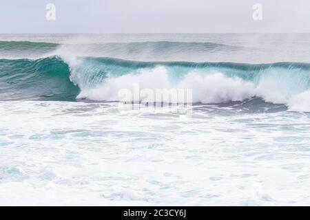 Meeresküste, Bewegungswellen mit Schaum. Windkraft. Türkisfarbenes Wasser. Stockfoto