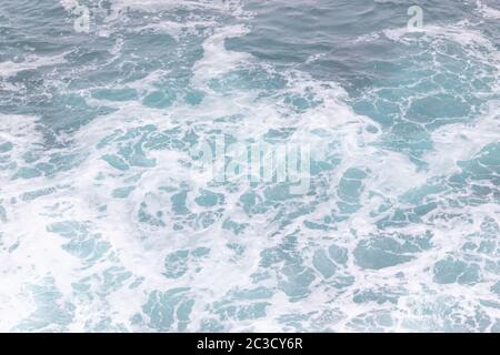 Meeresküste, Bewegungswellen mit Schaum. Windkraft. Türkisfarbenes Wasser. Stockfoto