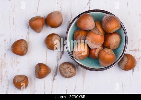 Haselnüsse in einer Schüssel auf weißem strukturiertem Hintergrund Stockfoto