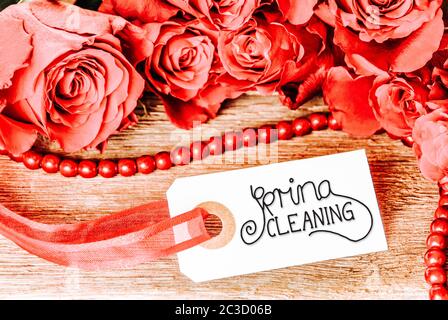 Ein Etikett Mit Englischer Kalligraphie Spring Cleaning. Rose Blume Blüte Auf Holzhintergrund Stockfoto