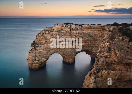 Foto des Naturbogens in Faro Portugal bei Sonnenuntergang. Stockfoto