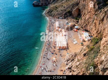 Felsiger Strand mit rosa Kieselsteinen und kristallklarem azurblauem Meer. Konzept der Reise, idealer Ort für Sommerurlaub am Meer in einem sicheren Ort. Speicherplatz kopieren Stockfoto