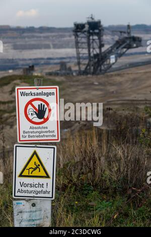 Zufahrtsverbotsschilder zum Tagebau Inden, einer offenen Braunkohlegrube von RWE in Nordrhein-Westfalen. Im Hintergrund ein Schaufelradbagger Stockfoto