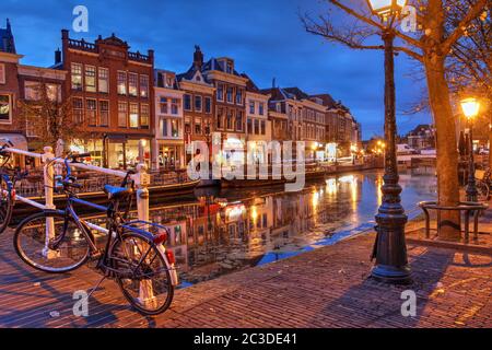 Nachtszene in Leiden, Niederlande mit alten Häusern am Nieuwe Rijn Kanal. Stockfoto