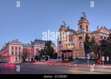 Dämmerung in Cluj Napoca, Rumänien mit dem Lucian Blaga Nationaltheater und dem Justizpalast. Stockfoto