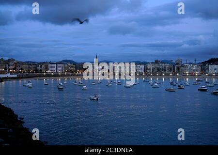 Der Blick auf die Bucht von La Concha mit der Stadt San Sebastian im Hintergrund bei der Dämmerung vom Hafen von San Sebastian.San Sebastian.Gipuzkoa.Baskenland.Spanien Stockfoto