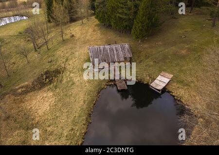 Drohnenansicht der alten verlassenen Hütte mitten im Wald während des Sommers Stockfoto