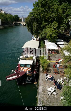 Ein Barge-Restaurant an der seine mit Sitzmöglichkeiten an Land im Freien.Paris.Frankreich Stockfoto