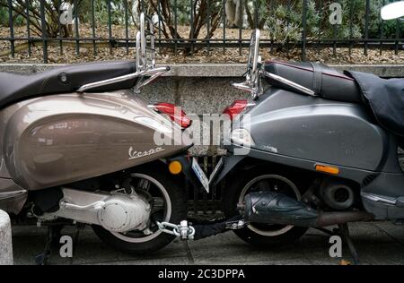 Zwei Vespa Motorroller, die zusammen auf dem Bürgersteig der Stadt einsperren.Paris.Frankreich Stockfoto