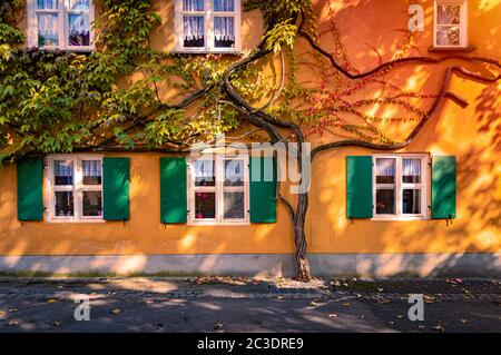 Die Fuggerei ist die älteste noch in Betrieb befindliche soziale Wohnanlage der Welt. Es ist eine ummauerte Enklave innerhalb der Stadt Augsburg, Bayern, Deutschland Stockfoto