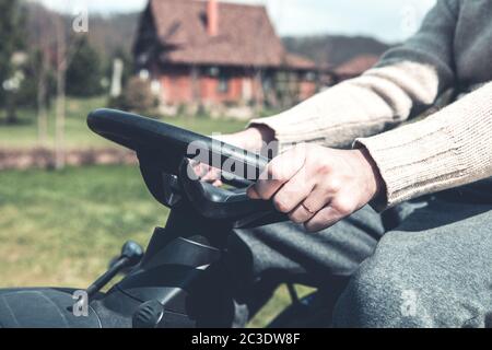 Mann, der während des Rasenmähers auf dem Hof arbeitet Stockfoto