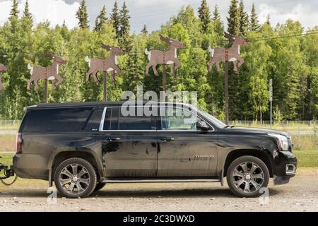 Ein staubbedeckter SUV, der unter fliegenden Rentieren am Santa Claus House in North Pole, Alaska, geparkt wurde. Der Weihnachtsladen ist ganzjährig geöffnet und ein beliebtes Touristenziel. Stockfoto