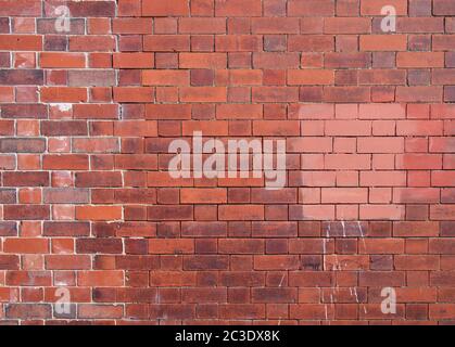 Eine alte reparierte geflickte Außenwand aus roten Ziegeln Stockfoto