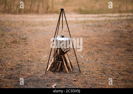 Vorbereitung von Lebensmitteln am Lagerfeuer in wilden Camping im Herbstwald Stockfoto