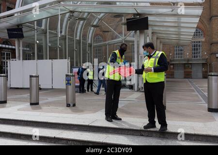 Mitarbeiter von Network Rail bringen Passagiere direkt von diesem jetzt nur ausfahrenden Eingang zum Bahnhof Liverpool Street in der City of London zu einer Alternative um die Ecke während der britischen Coronavirus-Pandemie. Die britische Regierung hat heute die nationale Covid-19-Alarmstufe von 4 auf 3 gesenkt, was bedeutet, dass das Virus als „im allgemeinen Umlauf“ mit „einer allmählichen Verringerung der Beschränkungen“ angesehen wird. Die Zahl der Todesfälle durch Coronavirus in den letzten 24 Stunden hat sich jedoch um 287 auf 37,979 erhöht, am 19. Juni 2020, in der City of London, England. Alle Fahrgäste im öffentlichen Nahverkehr sind Stockfoto