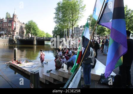 Aktivisten und Unterstützer der GLBTQ-Gemeinschaft nehmen am 19. Juni 2020 am Gedenkstand zur Erinnerung an Sarah Hegaziat im Homomonument inmitten des Coronavirus-Pandeminzes in Amsterdam, Niederlande, Teil. Sarah Hegazi, eine ägyptische queere kommunistische Aktivistin, starb am 14. Juni 2020 durch Selbstmord, nachdem sie vom Sissi-Regime brutal und gewaltsam inhaftiert worden war. Sie wurde eingesperrt, nachdem sie beim Maschrou Leïla Konzert 2017 eine Regenbogenfahne wedeln ließ. Öffentlicher Aufschrei und eine Kampagne der Demütigung führten zu ihrer Verhaftung. Sarah rannte nach Kanada, um Asyl zu suchen - und hinterließ die Familie und die Gemeinschaft, die sie verzweifelt ne Stockfoto