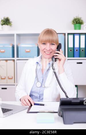 Ärztin, die bei der medizinischen Telefon-Hotline im Home Office berät. Grippe-Virus-Krankheit, Kommunik Stockfoto