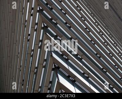 Nahaufnahme Detail der Ecke eines großen modernen Bürogebäudes mit geometrischen Metallic-Stahl-Linien Stockfoto