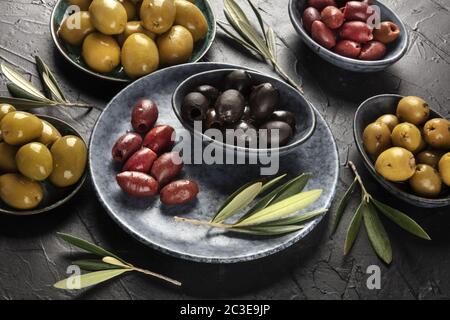 Oliven, grün, schwarz und rot, ein Sortiment in Schüsseln auf einem Tisch Stockfoto