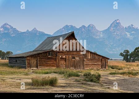 Morgensonnenaufgang über der T.A Molton Scheune im Mormon Row Historic District entlang der Antelope Flats mit den Grand Teton Bergen hinter dem Grand Teton National Park, Wyoming. Stockfoto